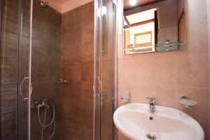 a bathroom with a sink and a shower with a mirror at Helena Hotel in Chania