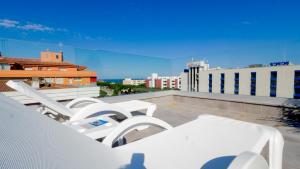a group of white lounge chairs on a roof at Hotel Riviera in Santa Susanna