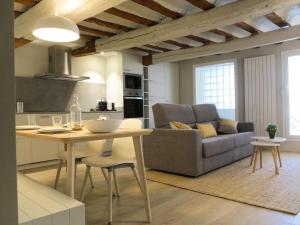 a kitchen and living room with a table and a couch at El Oasis de la Estafeta in Pamplona