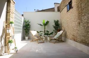 een patio met stoelen en planten op een gebouw bij El Oasis de la Estafeta in Pamplona
