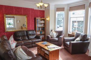 a living room with leather furniture and a mirror at Sunnyside Guest House in Keswick