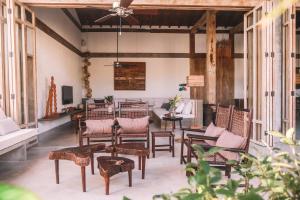 CasaMiaTrancoso في ترانكوسو: غرفة معيشة مع مجموعة من الكراسي والطاولات