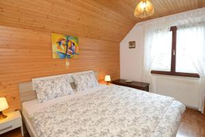een slaapkamer met een bed en een houten muur bij Brane Apartment in Bohinj