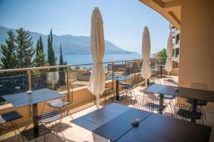 a balcony with tables and chairs and a view of the water at Hotel Harmonia by Dukley in Budva