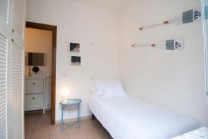 a bedroom with a bed and a stool and a table at Forte 27 centro in Forte dei Marmi