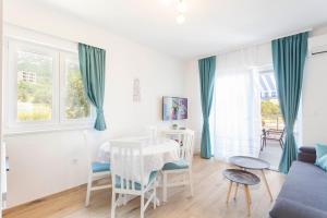 a white living room with a table and chairs at Blue House in Makarska