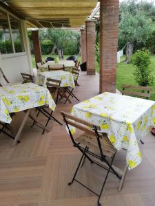 two tables with yellow and white table cloths on a patio at Bed&Breakfast La Zagara in Querceta