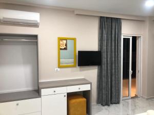 a living room with a tv on the wall at Summer Gate Hotel in Ksamil