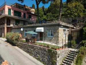 dom z kamienną ścianą obok ulicy w obiekcie Villetta Margherita w Rapallo
