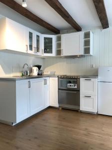 a white kitchen with white cabinets and appliances at The White House in Bergen