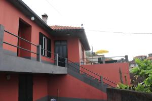 a red building with a balcony on the side of it at Casa reizinho in Santana