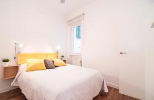 マドリードにあるPrecioso apartamento San cosmeのベッドルーム(白い大型ベッド、黄色い枕付)