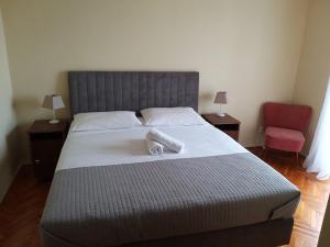 a bedroom with a large bed and a red chair at Apartment and Rooms Villa Kolonada in Vodice +11 photos
