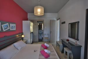 a bedroom with a bed with red walls and a desk at Kini Bay in Kini