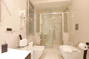 a white bathroom with a shower and a toilet at REGGIA & DINTORNI ROOMS A CASERTA in Caserta +28 photos