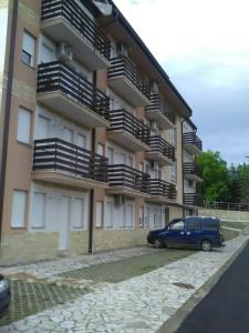 ein blaues Auto, das vor einem Gebäude parkt in der Unterkunft Apartman Jevtić 1 in Gornja Toplica