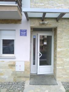 Eine weiße Tür auf einem Gebäude mit einem Schild drauf. in der Unterkunft Apartman Jevtić 1 in Gornja Toplica