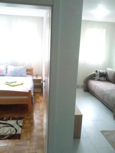 a living room with a bed and a couch at Apartman Jevtić 1 in Gornja Toplica