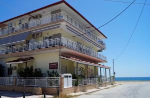 a building with balconies and the ocean in the background at House Kohili in Nea Vrasna