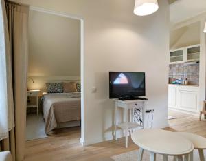 a small living room with a bed and a television at Poilsio burės in Nida