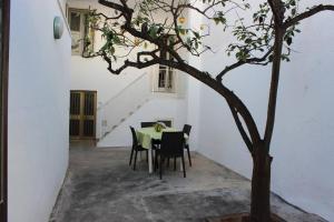 a table and chairs in a room with a tree at A Casa di Anna in Specchia