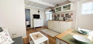 a kitchen with white cabinets and a table in a room at Poilsio burės in Nida