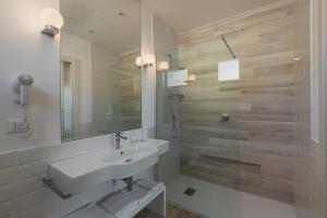 a white bathroom with a sink and a shower at Il Gallo Bianco in Cagliari