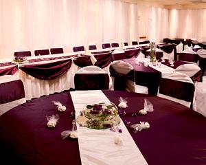 a banquet hall with purple and white tables and chairs at Ramada by Wyndham Marquette in Marquette