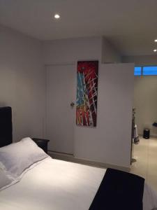 1 dormitorio con 1 cama y una pintura en la pared en SPACIOUS STUDIO CENTRAL LOCATION (201), en Bogotá