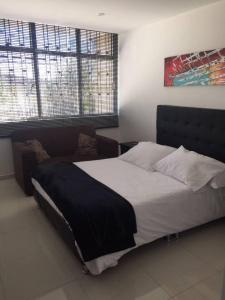 a bedroom with a large bed and two windows at SPACIOUS STUDIO CENTRAL LOCATION (201) in Bogotá