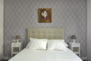 a bedroom with a white bed with two night stands at Apartment Ronda Sant Antoni in Girona
