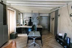 a living room with a table and a kitchen at Flora Inn, Flora I - Nel cuore di Bergamo Alta in Bergamo
