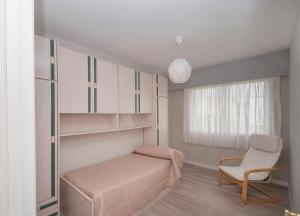 a bedroom with a bed and a chair and a window at AMPLIO APARTAMENTO EN BURELA in Burela de Cabo