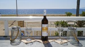 a bottle of wine sitting on a table with two glasses at House Kohili in Nea Vrasna