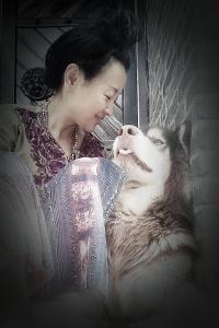 een vrouw in een stoel met een hond bij Guixu Huatang Homestay in Qinhuangdao