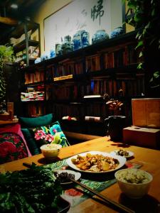 une table en bois avec deux assiettes de nourriture dans l'établissement Guixu Huatang Homestay, à Qinhuangdao