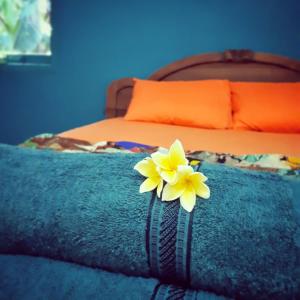 a yellow flower on a blue blanket on a bed at L'isola che... in Karimunjawa