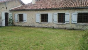 une vieille maison en pierre avec des fenêtres blanches et une cour dans l'établissement hâvre de paix en Gascogne, à Courrensan