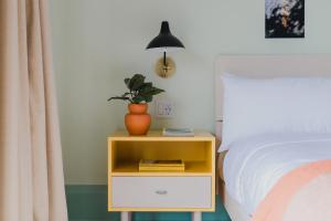 a nightstand with a plant on it next to a bed at Drake Motor Inn in Wellington