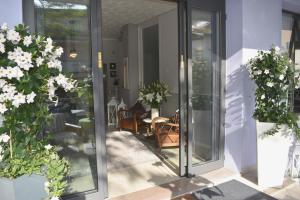 a glass door leading to a patio with flowers at Hotel My Fair in Lido di Jesolo