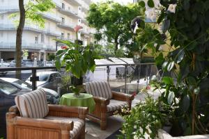 un patio con 2 sedie e un tavolo con piante di Hotel My Fair a Lido di Jesolo