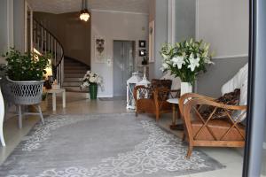 a hallway with chairs and a table with flowers at Hotel My Fair in Lido di Jesolo