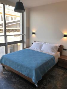 um quarto com uma cama grande e um cobertor azul em Ladadika 5th Floor em Tessalônica