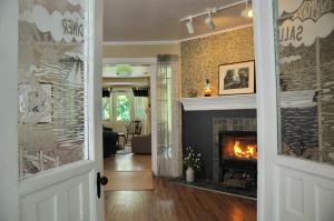 a living room with a fireplace and a fire place at Auberge Beausejour in Les Éboulements