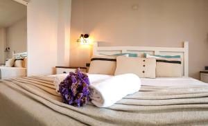 A bed or beds in a room at Bi Salkım Bozcaada Otel