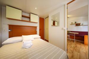 a bedroom with a large bed and a desk at Mobile Home Grbe in Nin +60 photos