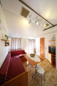 a room with red chairs and a table in a room at Mobile Home Grbe in Nin