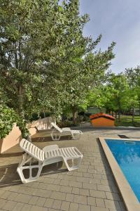 a group of lounge chairs next to a swimming pool at Mobile Home Grbe in Nin