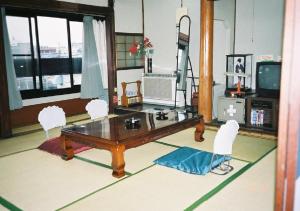 a living room with a wooden table and chairs at Komecho Ryokan / Vacation STAY 36247 in Imabari