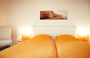a bedroom with two beds and a picture of a beach at Ferienwohnungen Gaebert in Kellenhusen